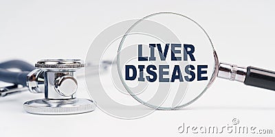 There is a stethoscope on the table, a magnifying glass with the inscription - Liver Disease Stock Photo