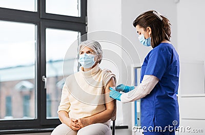 nurse applying medical patch to vaccinated woman Stock Photo