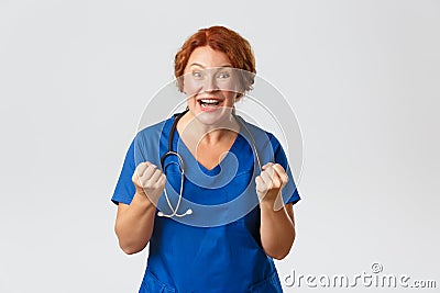 Medicine, healthcare and coronavirus concept. Excited middle-aged doctor, female medical worker fist pump and saying yes Stock Photo