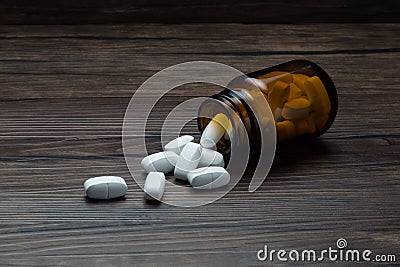 medicine pill tablet with spilled bottle on wooden table Stock Photo