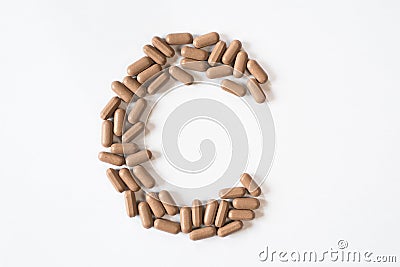 Medicine pills forming letter C, symbolic of vitamin C Stock Photo