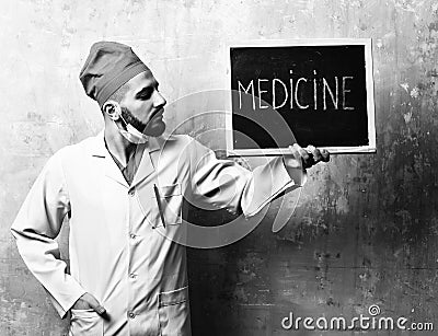 Medicine word written on blackboard which is held by doctor Stock Photo