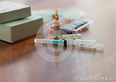 Medicines, injectable ampoules and syringe on the table Stock Photo
