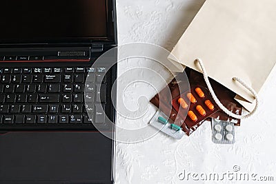 Medicines and pills next to laptop, notebook keyboard. Stress in the work, Anti virus Stock Photo