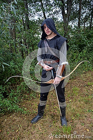 Medieval archer with black hood and coloured arrows in the quiver stands with arrow Stock Photo