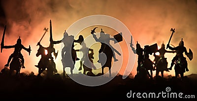 Medieval battle scene with cavalry and infantry. Silhouettes of figures as separate objects, fight between warriors on dark toned Stock Photo