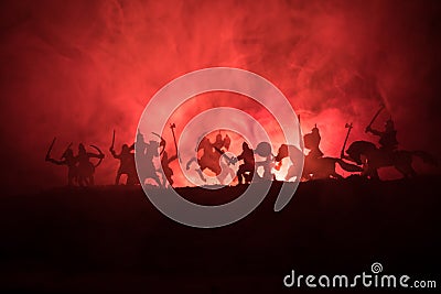 Medieval battle scene with cavalry and infantry. Silhouettes of figures as separate objects, fight between warriors on dark toned Stock Photo