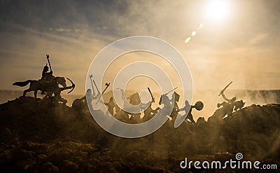 Medieval battle scene with cavalry and infantry. Silhouettes of figures as separate objects, fight between warriors on sunset fogg Stock Photo