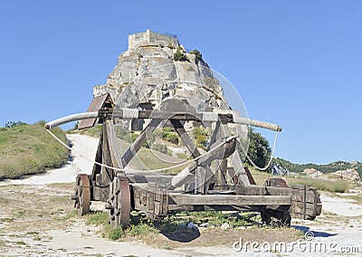 Medieval catapult in front of hilltop castle Stock Photo