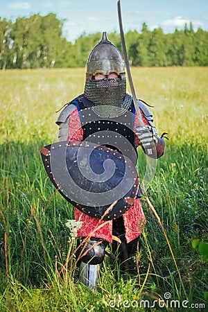 A medieval Central Asian warrior a nomad in 14th-century armor stands in a defensive or attacking position Stock Photo