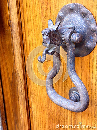 A medieval doorknocker on a wooden door in a Tuscan hill town Italy Stock Photo