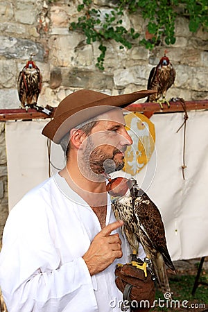 Medieval dressed falconer with hooded falcon Editorial Stock Photo