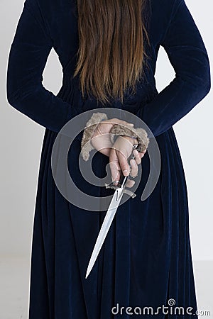 A Medieval and Fantasy woman wearing a blue velvet dress and holding a dagger Stock Photo