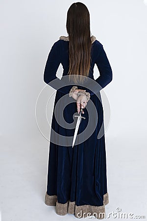 A Medieval and Fantasy woman wearing a blue velvet dress and holding a dagger Stock Photo