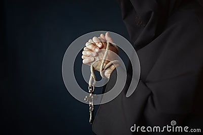 Medieval friar praying with wooden cross in hands Stock Photo