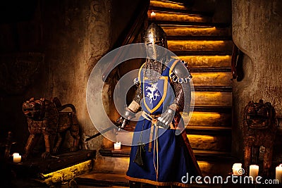 Medieval knight on guard in ancient castle interior. Stock Photo