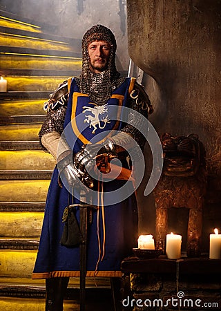 Medieval knight on guard in ancient castle interior. Stock Photo