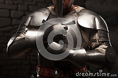 Medieval knight kneeling with sword Stock Photo
