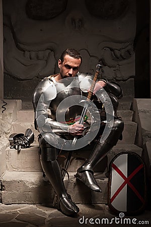 Medieval knight sitting on the steps of ancient Stock Photo