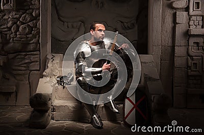 Medieval knight sitting on the steps of ancient Stock Photo