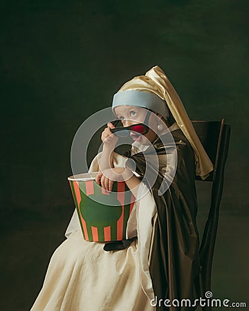Medieval little girl as a lady with a pearl earring on dark studio background. Concept of comparison of eras, childhood Stock Photo