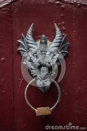 Dragon head door knocker on red wooden door Stock Photo