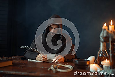 Medieval monk sitting at table and write, top view Stock Photo