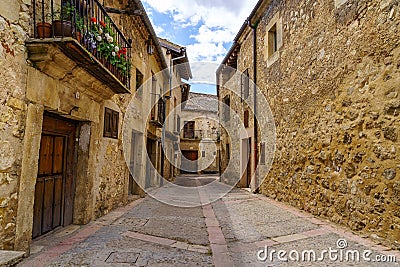 Medieval old town with stone houses, old doors and windows, cobbled streets and picturesque atmosphere. Pedraza, Segovia, Spain Stock Photo