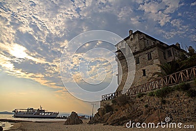 Medieval Ouranoupoli Tower with pilgrims ferry boat, Chalkidiki, Greece Stock Photo