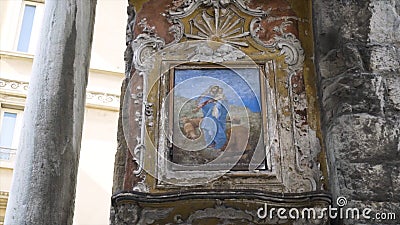 Medieval painting on castle wall. Action. Battered old painting or icon weighs on stone wall of medieval building Editorial Stock Photo