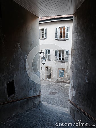 Medieval paved street and an old house with windows with wooden shutters seen from a narrow alley with stairs in the Old Town of G Stock Photo
