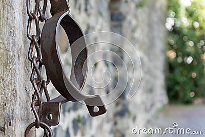 Medieval prison chains for prisoners in front of stone wall Stock Photo