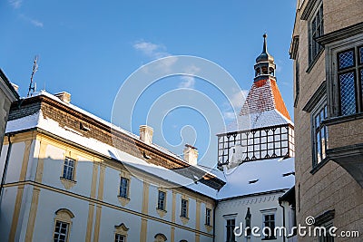 Medieval renaissance water castle with half-timbered tower with snow in winter sunny day, Historic Romantic chateau Blatna near Editorial Stock Photo