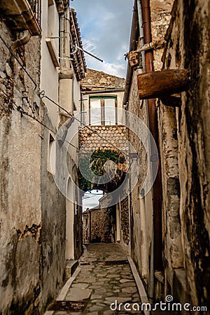 Medieval Rocca Imperiale: Italian Street with Old Houses, Stone Floors, and the street continues to a gate under the house Stock Photo