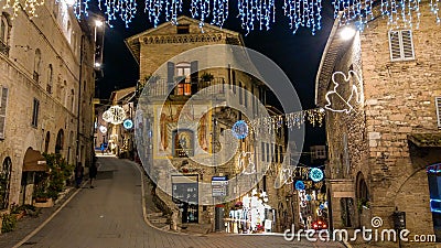 Medieval street of Assisi with christmas decorations at winter night, Umbria Editorial Stock Photo