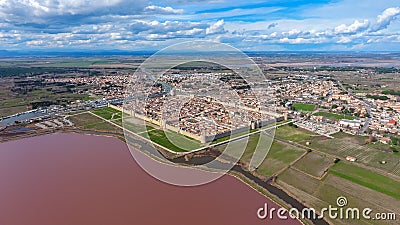 Medieval town fortress on the shore of the pink lake in France. Stock Photo