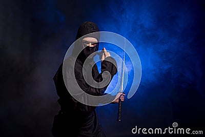 Medieval warrior ninja assassin throws shuriken in smoke Stock Photo