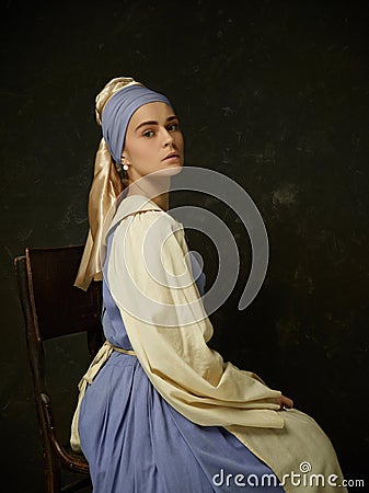 Medieval Woman in Historical Costume Wearing Corset Dress and Bonnet. Stock Photo