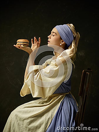 Medieval Woman in Historical Costume Wearing Corset Dress and Bonnet. Stock Photo