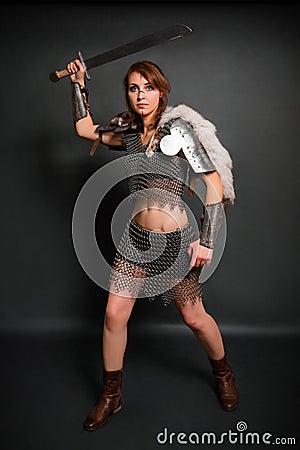 Medieval woman warrior in chain mail armor with lamellar bracers and lamellar shoulder pads with polar fox fur Stock Photo