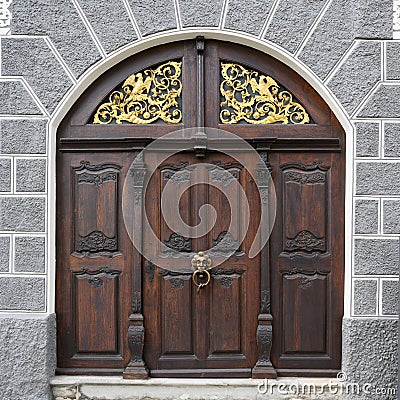 Medieval wooden door with lion head doorknocker and golden iron decoration, Ulm, South Germany Stock Photo