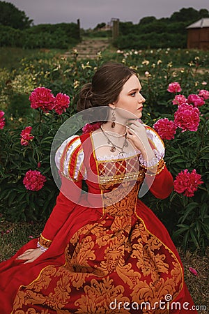 Medieval young princess in peony garden Stock Photo