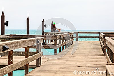 Meditating single man on the pier, coastline of Swakopmund Editorial Stock Photo