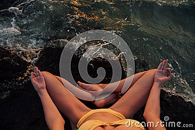 Meditation girl lotus position on stone on the background of the stunning sea. Stock Photo