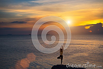 Meditation girl on the sea during sunset. Yoga silhouette. Stock Photo