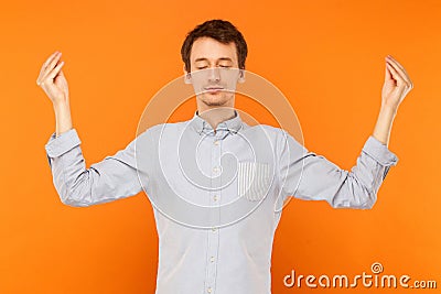 Meditation, mental practice. Young adult man closed eyes and doing yoga Stock Photo