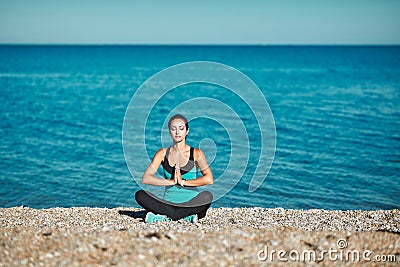 Meditation sitting on warm beach rocks. Stunning nature view and fresh air. Yoga time and healthy lifestyle concept Stock Photo