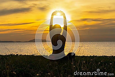 Meditation yoga lifestyle woman silhouette on the Sea sunset, relax vital. Stock Photo