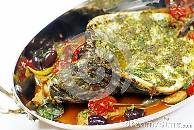 mediterranean baked sea bass fish with tomato, caper, artichoke, olive sauce Stock Photo