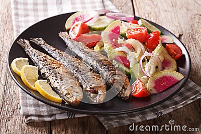 Mediterranean food: grilled sardines with fresh vegetable salad Stock Photo